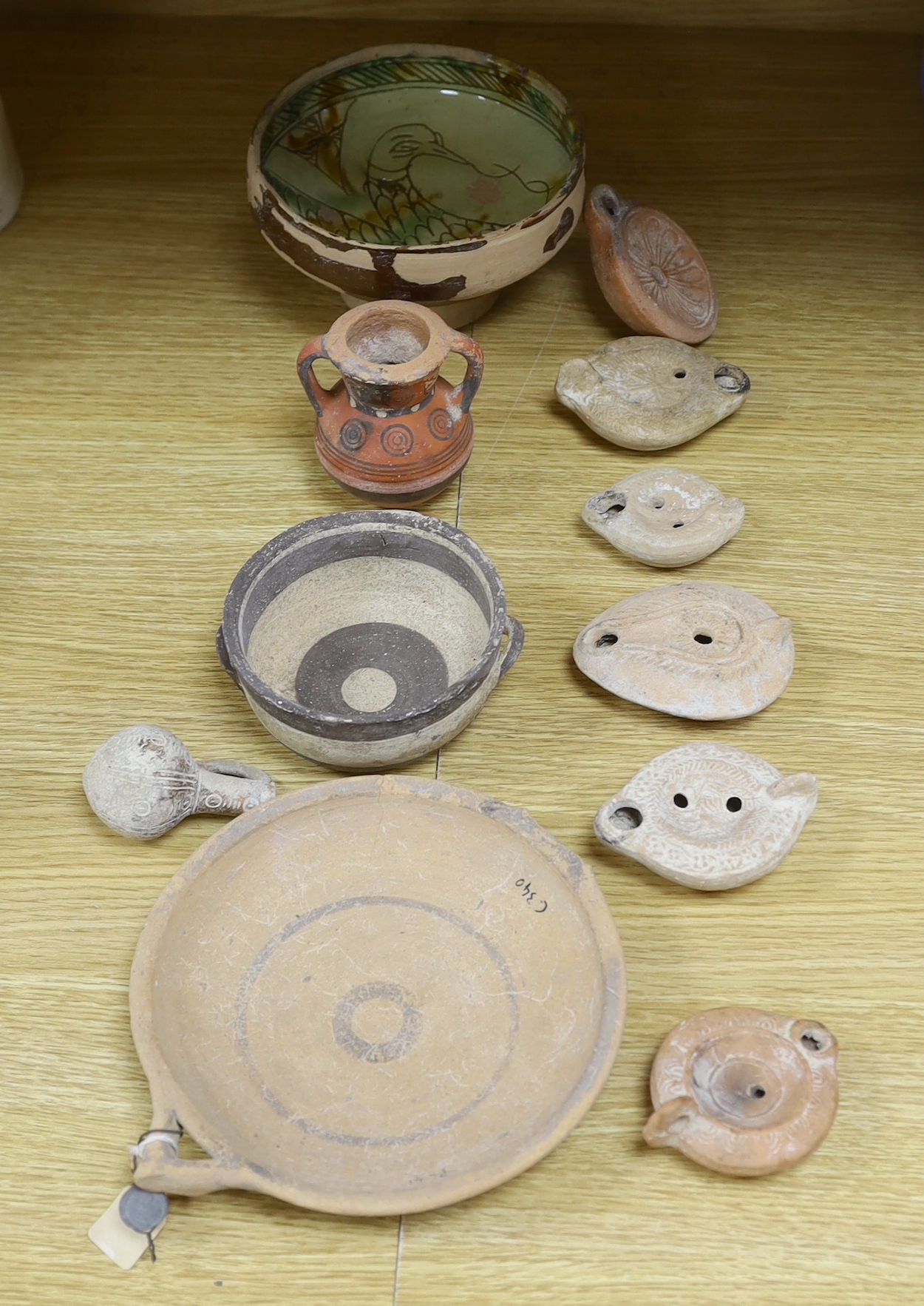 Assorted Cypriot pottery ‘antiquities’, to include bichrome pottery vessels, Cypro-Archaic, c.750-600 BC, Roman terracotta oil lamps, a Byzantine sgraffito ‘phoenix’ bowl, 13th/14th century, 16cm. Provenance - collected